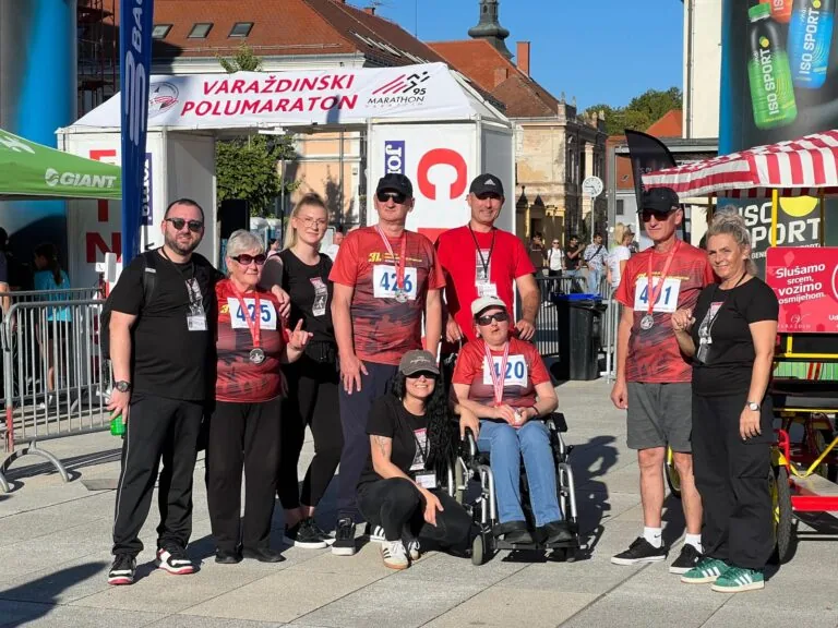 International participants and supporters smiling together at the race venue in Varaždin