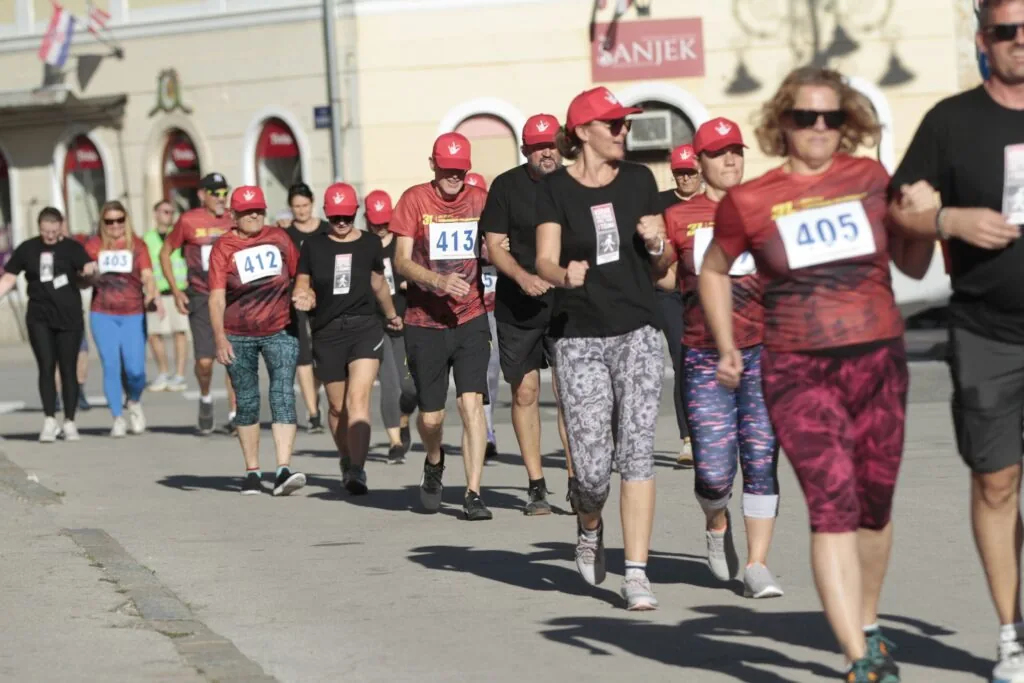 Deafblind participants and their accompanying support people walking together through central Varaždin during the 2025 race