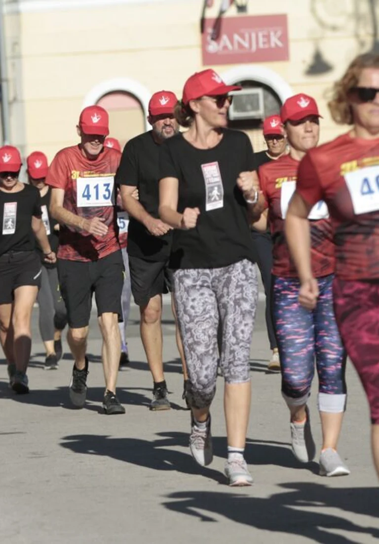Deafblind participants walking with their support people on a street in central Varaždin during the first race